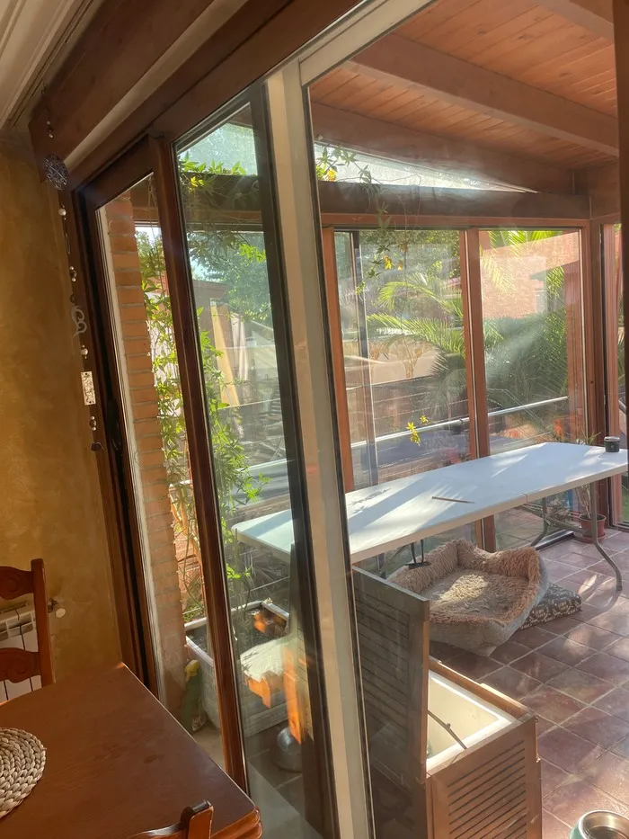 Detalle de perfilería de puerta de aluminio con vistas a jardín y terraza luminosa