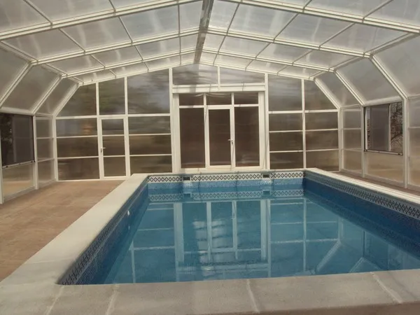 Vista interior de cubierta para piscina con puerta de aluminio
