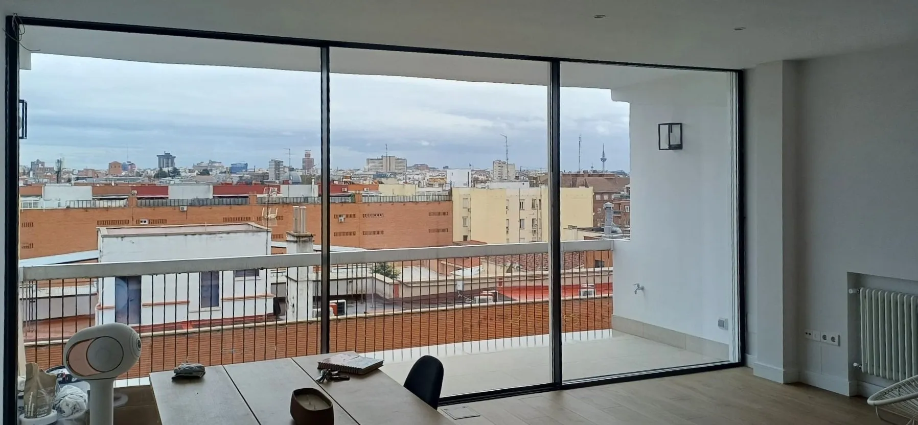 Gran cristalera de fachada con vistas panorámicas a la ciudad desde interior de vivienda