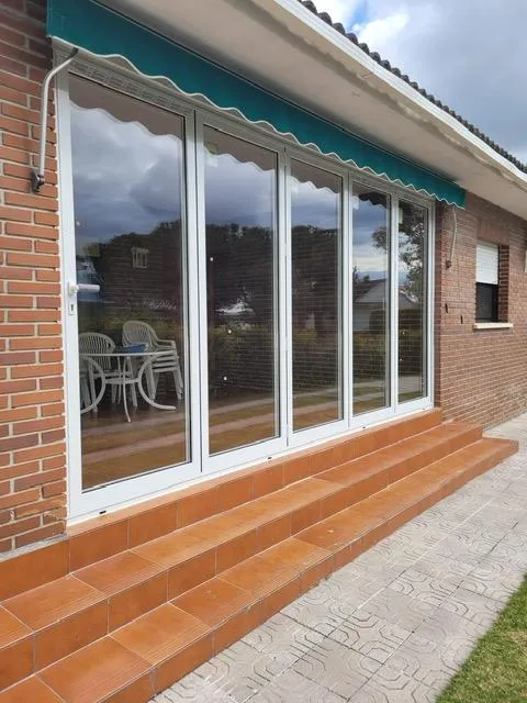 Puerta de aluminio acristalada para terraza con toldo