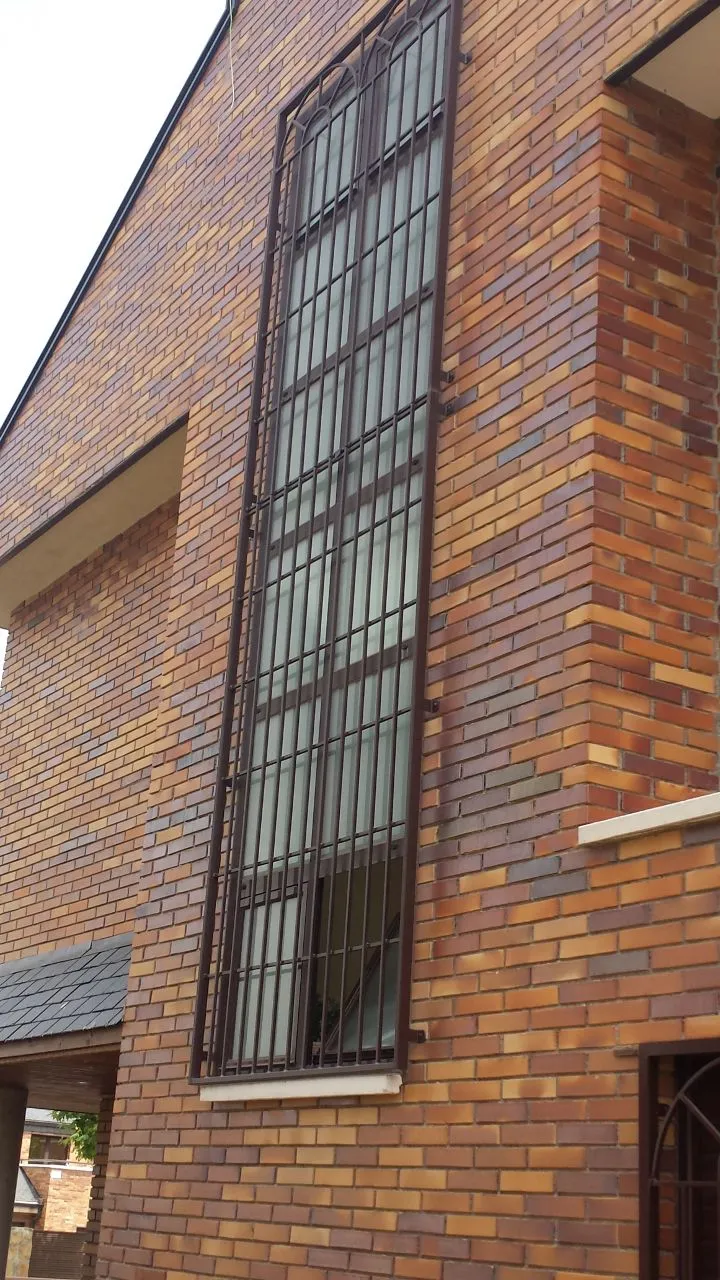 Ventana protegida con rejas en fachada de ladrillo