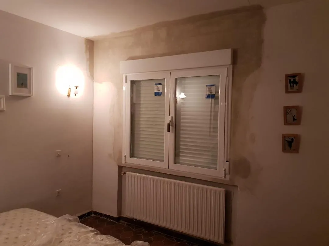 Ventana de aluminio con persiana en dormitorio