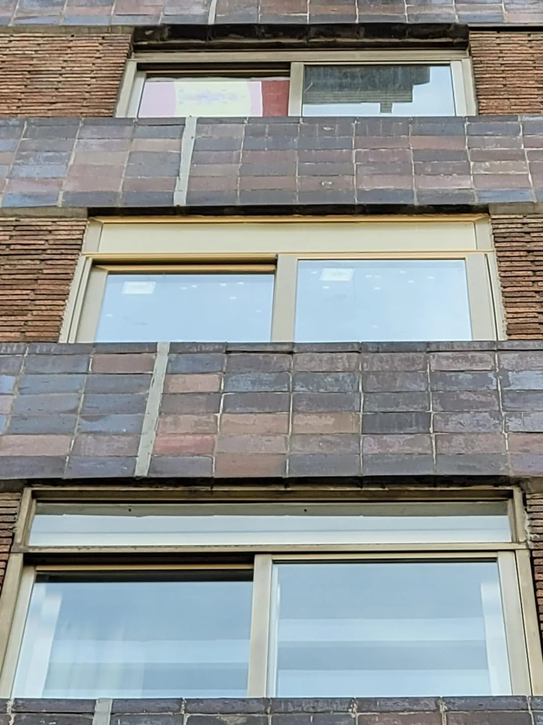 Ventana de aluminio instalada en fachada de ladrillo